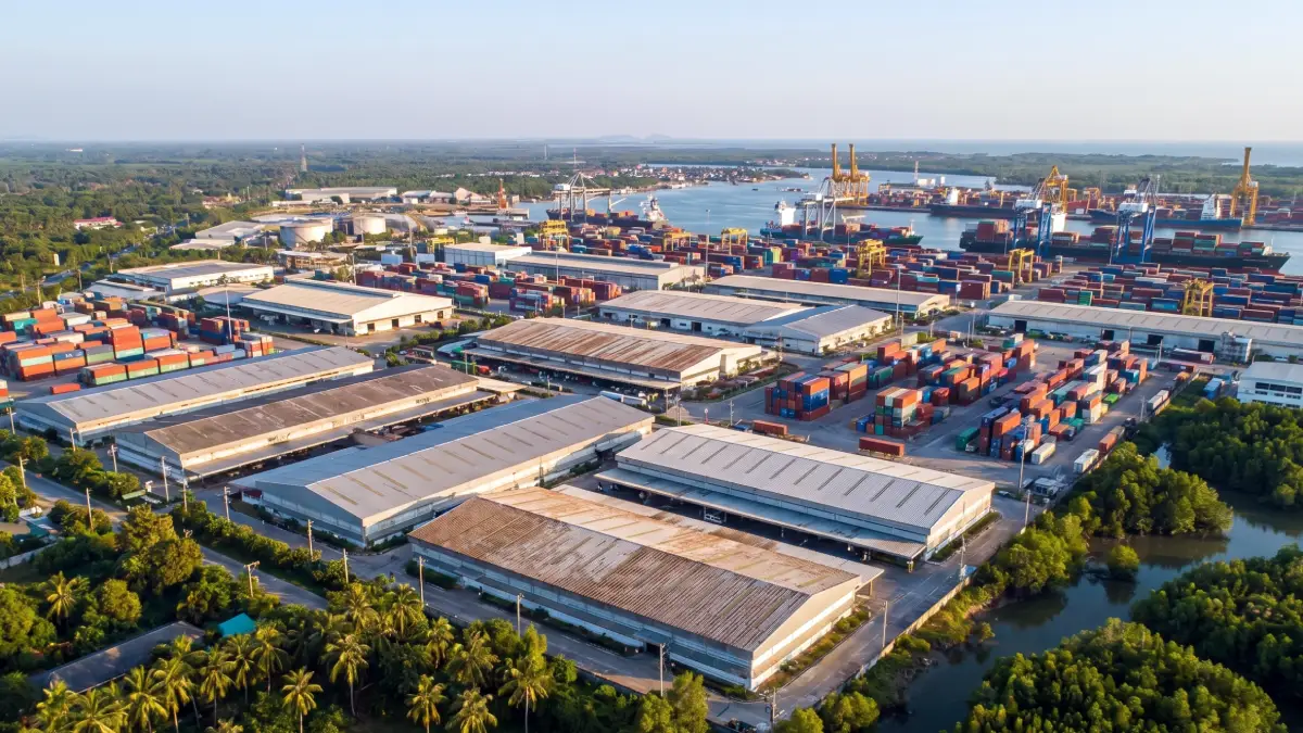 Vue aérienne d'une zone industrielle Free Zone en Thaïlande avec entrepôts, conteneurs et port maritime à l'arrière-plan — exemple de zone franche IEAT